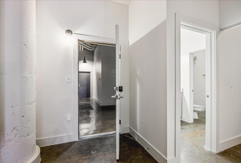 White painted interior with exposed concrete flooring, a visible concrete support column, and clean white trim