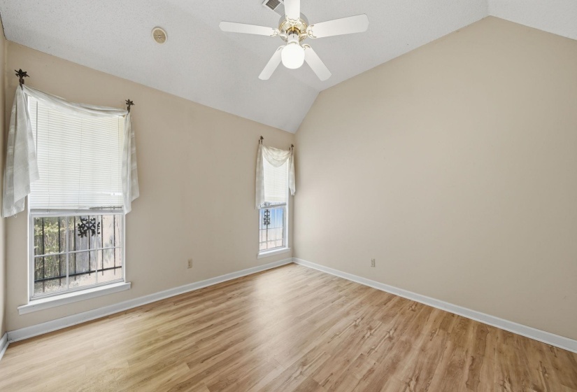 Room featuring wood-finish flooring, vaulted ceiling, and a ceiling fan