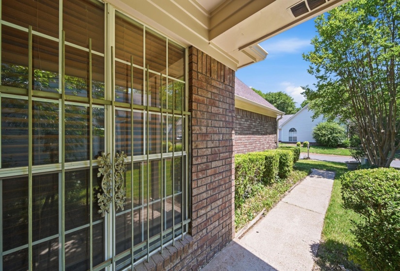 Brick exterior featuring a large window with decorative security bars