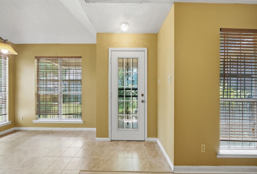 Entryway featuring a white door with decorative glass inserts, surrounded by warm-toned walls