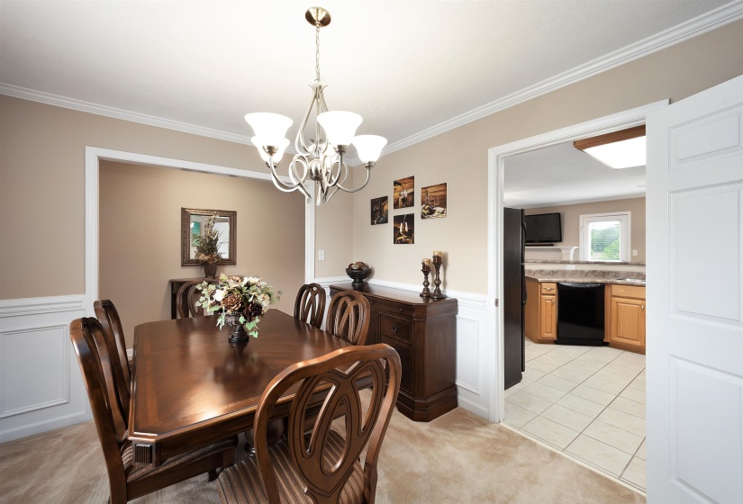 Formal dining area featuring a chandelier, crown molding, and wainscoting