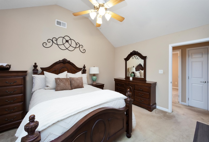 Vaulted ceiling bedroom featuring wall-to-wall carpeting and a ceiling fan with integrated lighting