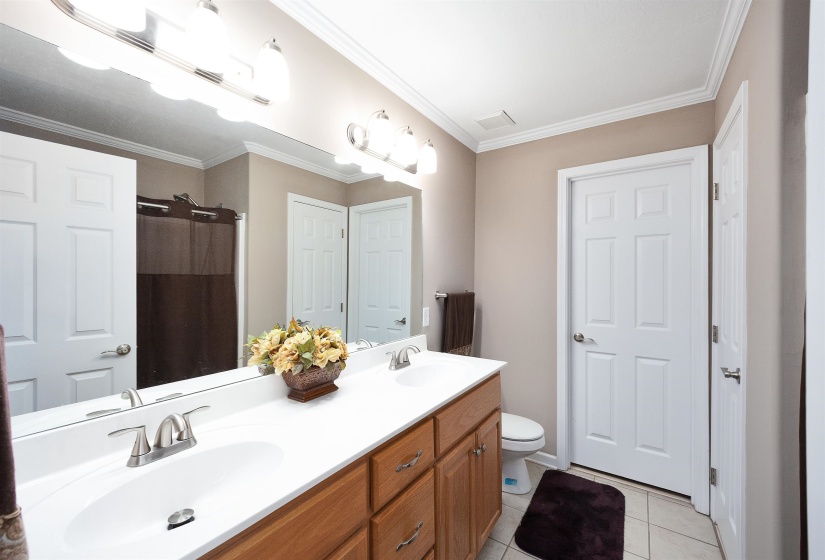 Bathroom featuring a dual-sink vanity with wood-finish cabinetry, white countertops, and brushed nickel faucets