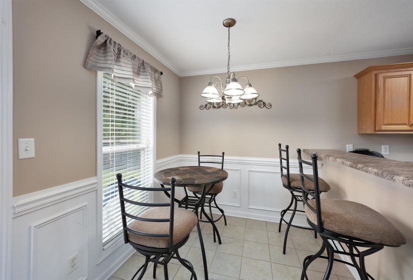 Dining area featuring a window with blinds, a chandelier, and tile flooring
