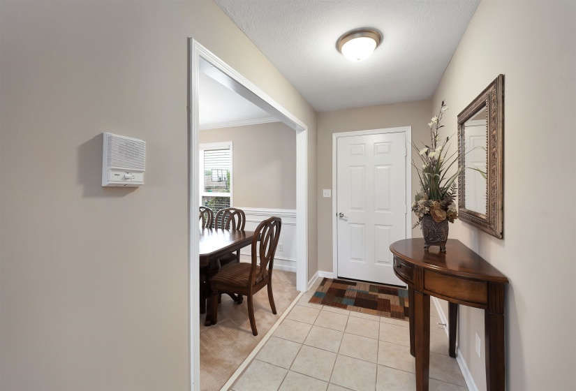 Foyer featuring tile flooring, a paneled entry door, and a flush-mount ceiling light