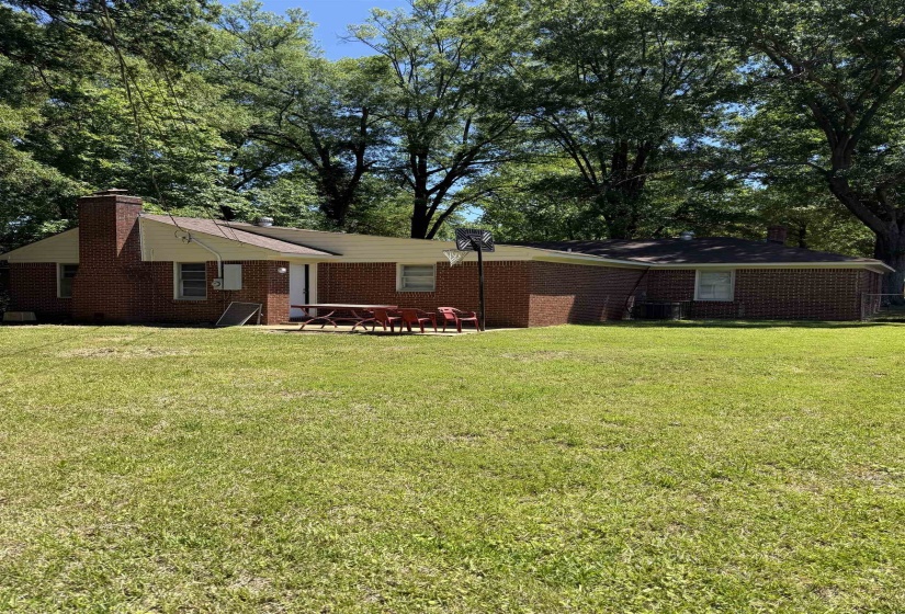 Expansive green lawn with mature perimeter trees