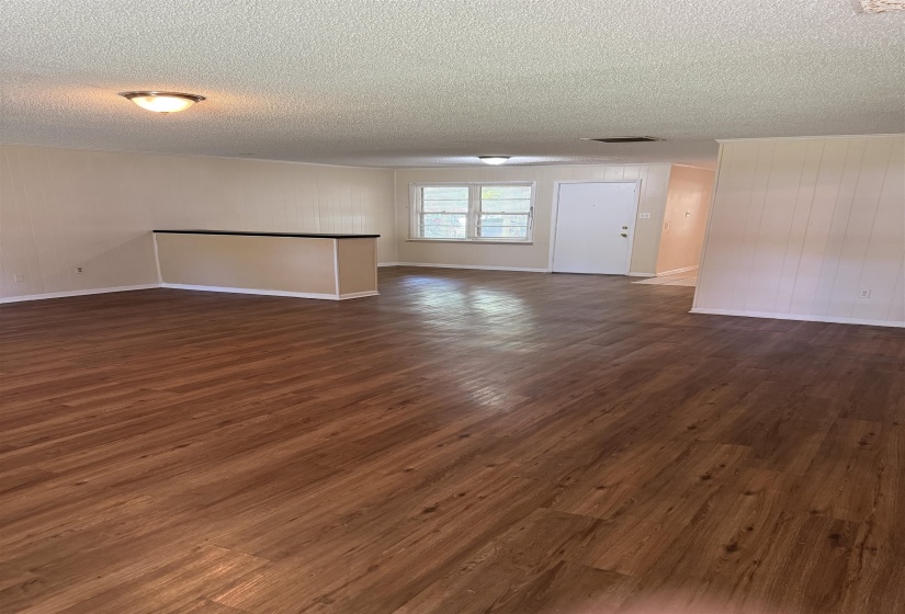 Spacious interior featuring wood-finish flooring, light-toned walls, and recessed lighting