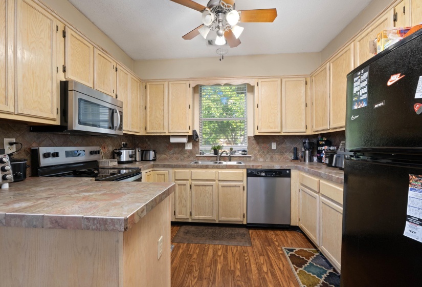 U-shaped kitchen featuring wood-finish cabinetry and flooring