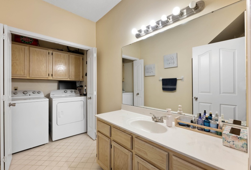 Bathroom vanity featuring a single basin sink, laminate countertop, and wood-finish cabinetry