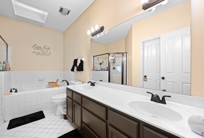 Bathroom with dual-sink vanity featuring a dark wood-finish cabinet and white countertop