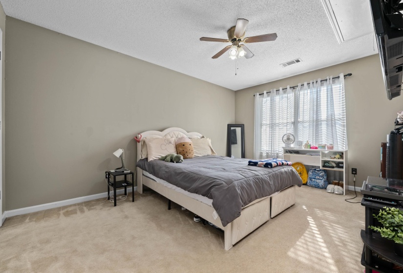 Carpeted room with neutral wall tones and a ceiling fan with integrated lighting