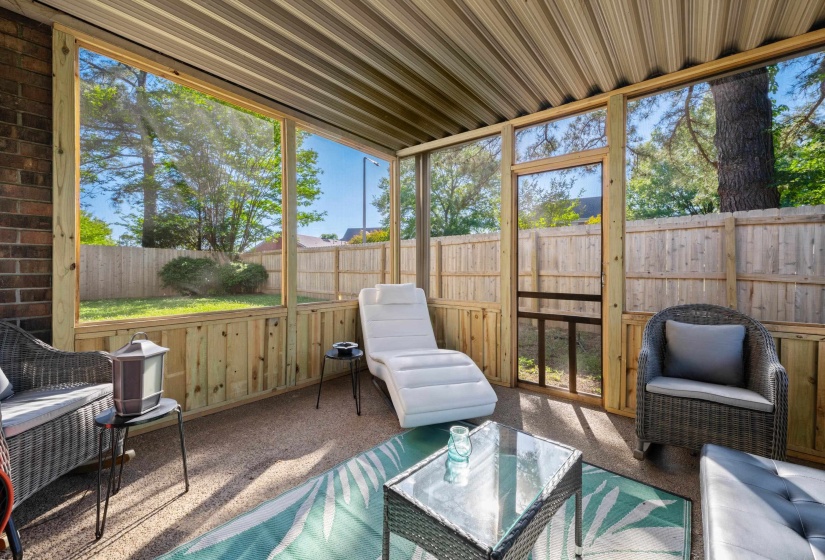 Screened porch featuring a metal roof, wood framing, brick exterior wall, and access to a fenced backyard