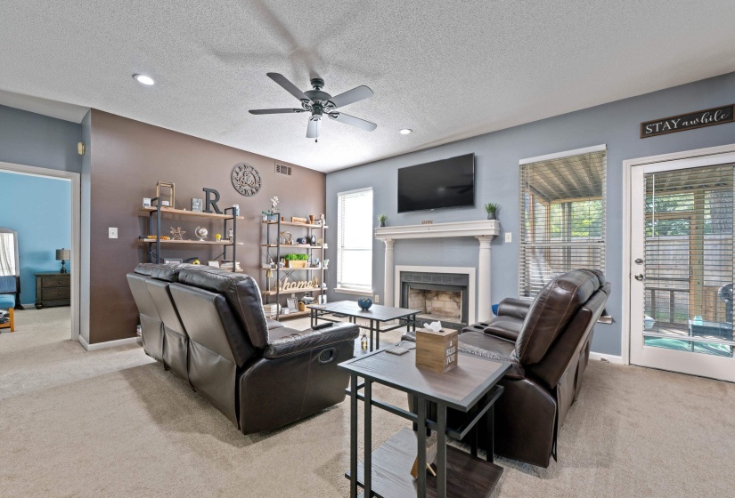 Living area featuring a white mantel fireplace, recessed lighting, and a ceiling fan