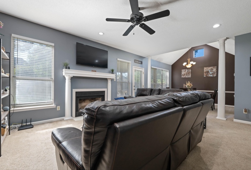 Living area featuring a fireplace with a white mantel, recessed lighting, and a ceiling fan