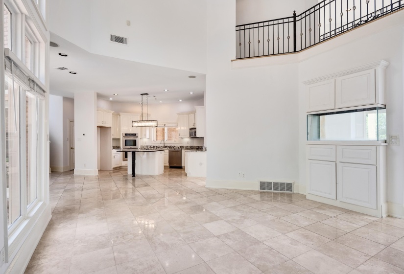 Two-story living area with tile flooring and abundant natural light from large windows