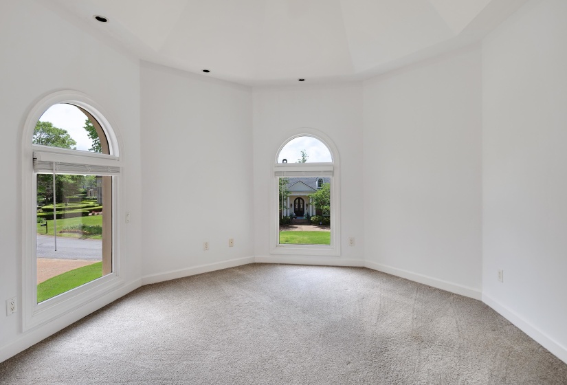 Bay window with arched top windows, white trim, recessed lighting, and light grey carpet flooring