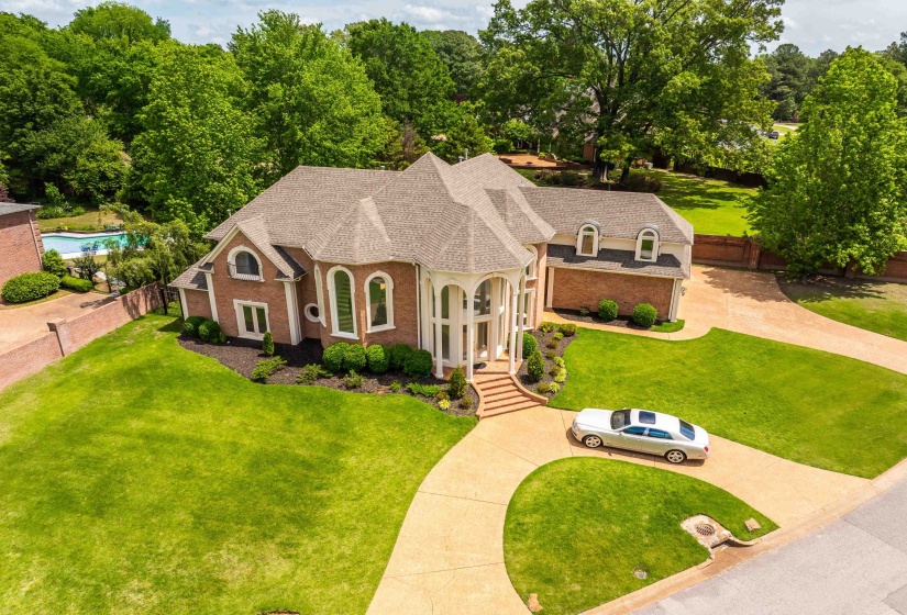Stately brick residence featuring a grand entrance with a columned portico and arched windows