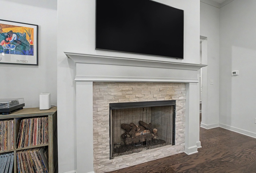 Fireplace featuring a stone tile surround, a dark metal firebox, and a substantial white mantel