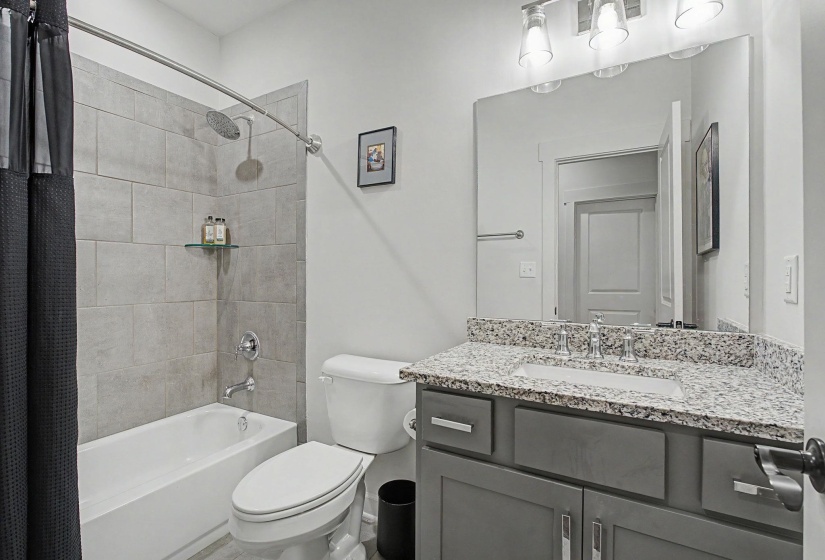 Full bathroom featuring a tub/shower combination with light gray wall tiling and a rainfall showerhead