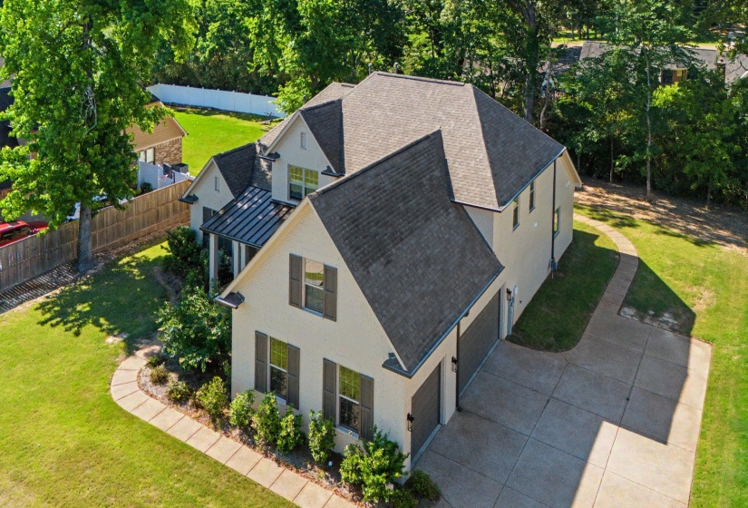 Two-story residence featuring light-colored siding, dark shutters, and a multi-gabled roofline