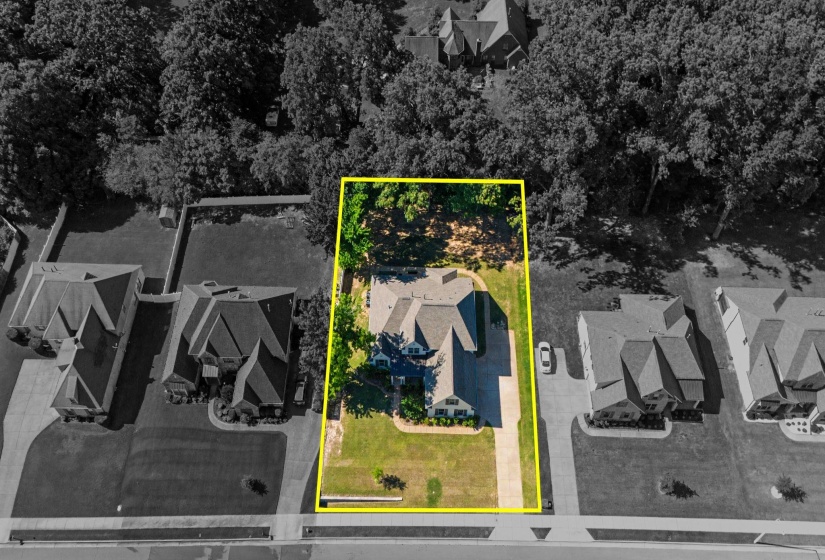 Expansive property featuring a large residence with a multi-gabled roof, a substantial front lawn, and a paved driveway