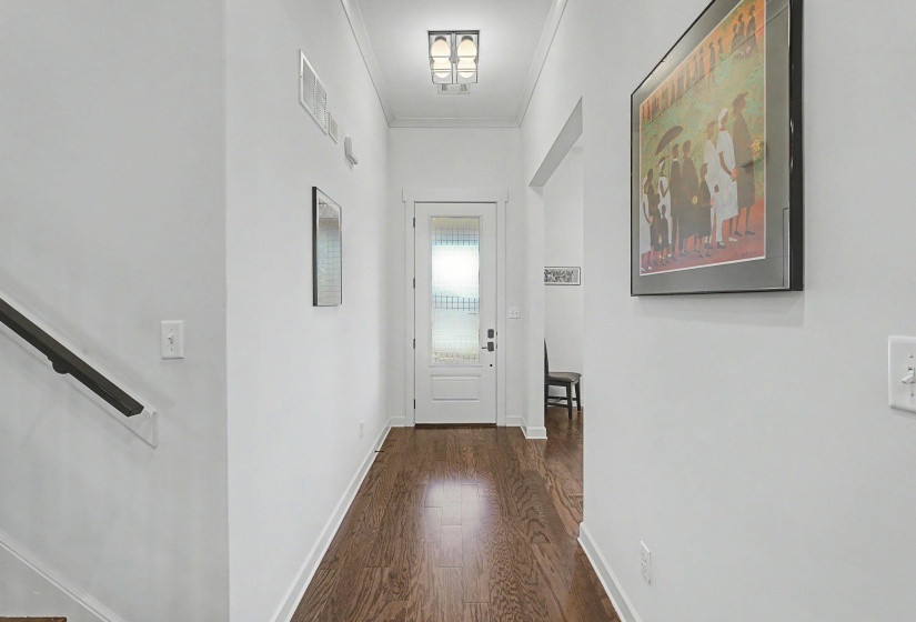 Entryway featuring wood-finish flooring, white trim, and a frosted glass panel door