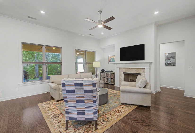 Living area featuring rich wood-finish flooring and recessed lighting