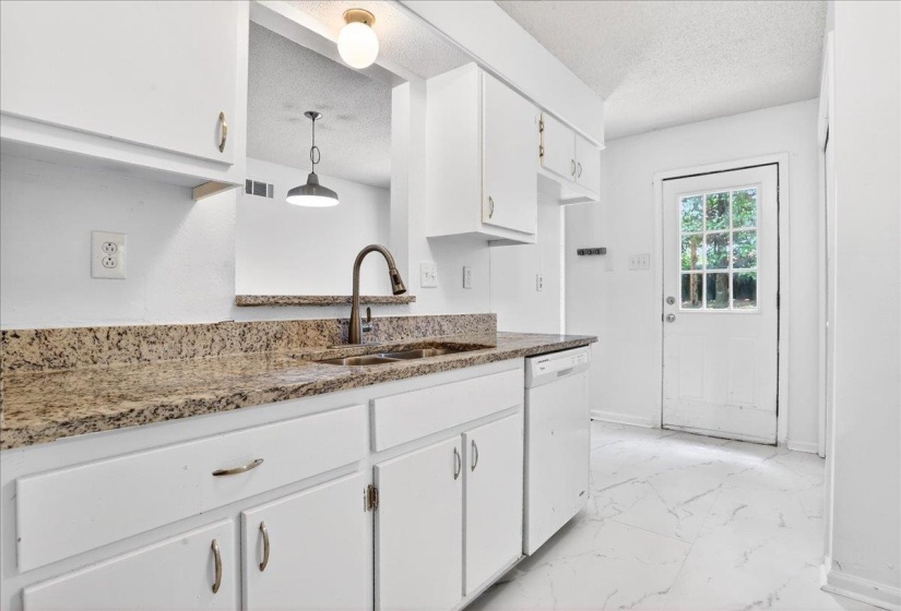 Kitchen featuring white cabinetry and light-toned countertops