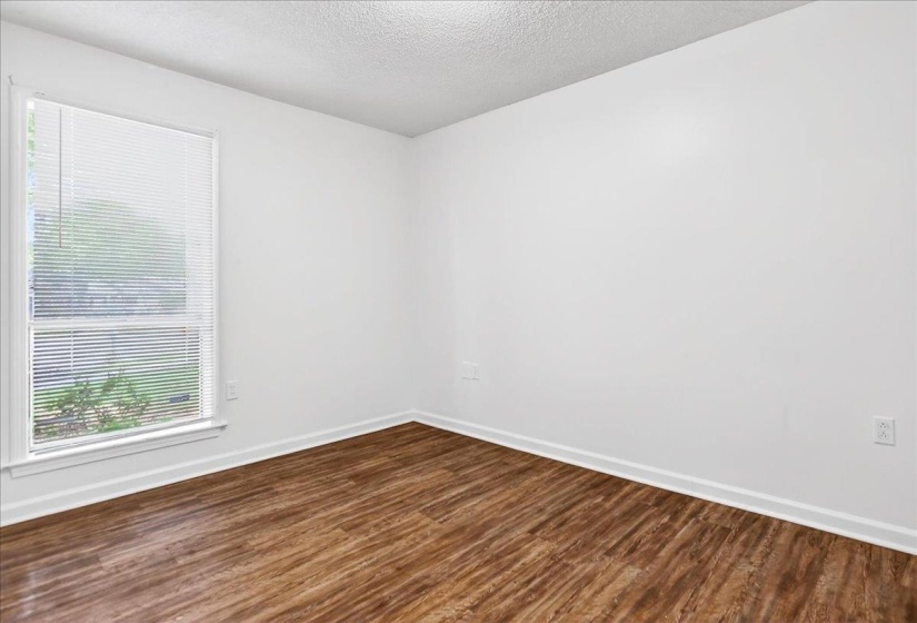 Interior room featuring wood-finish flooring and white baseboards