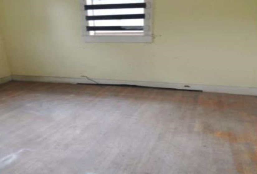 Wood-finish flooring with baseboards and light-colored walls