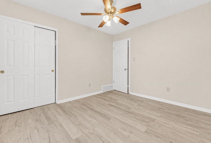 Interior room featuring wood-finish flooring, light neutral-toned walls, and white trim