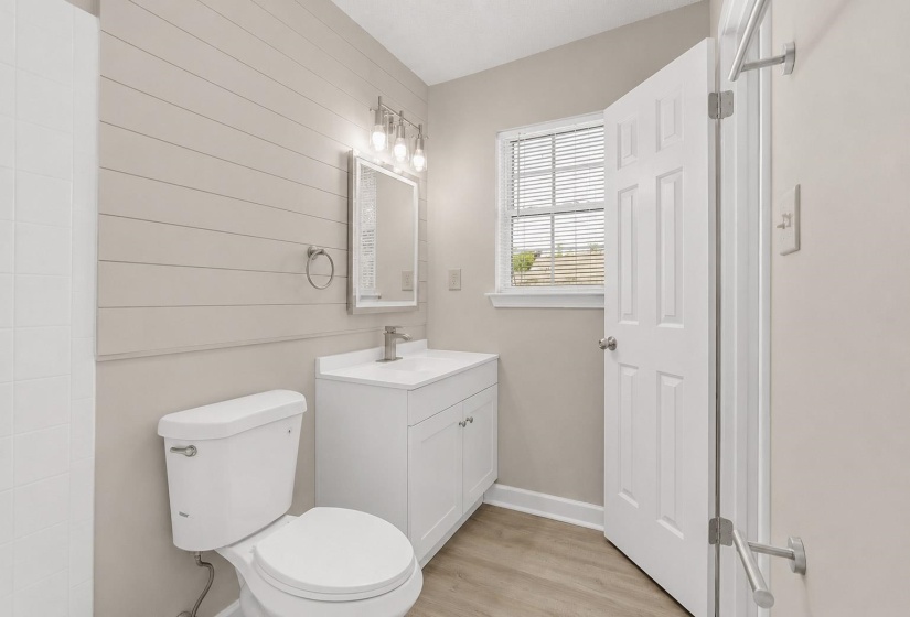Bathroom featuring a white vanity with integrated sink, brushed nickel faucet, and coordinating mirror with vanity lighting