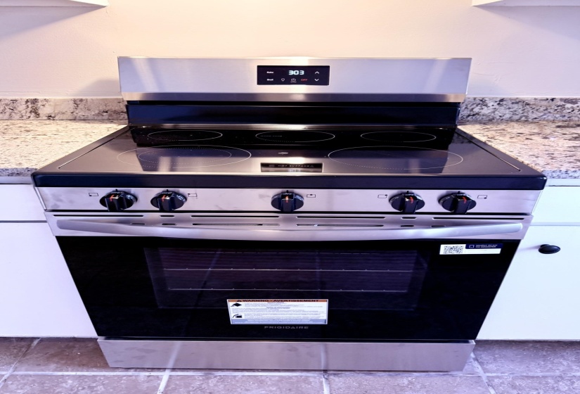 Stainless steel range with a glass cooktop and integrated digital display