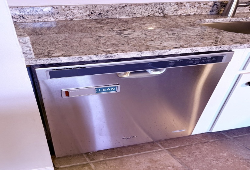 Stainless steel dishwasher integrated below a patterned countertop