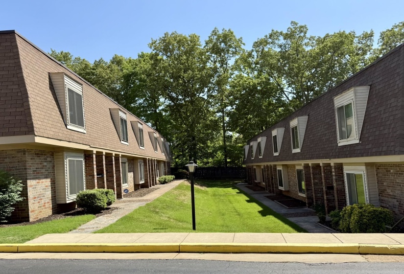 Brick townhomes featuring mansard roofs and multiple dormer windows