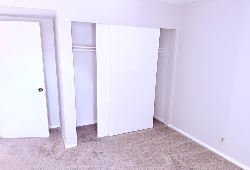 Neutral-toned carpeting paired with white baseboards and walls