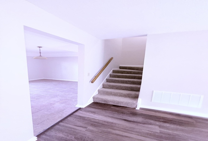 Carpeted staircase with wood handrail