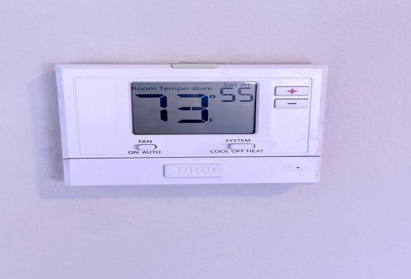Digital thermostat featuring a clear display of room temperature and set temperature, with fan and system control options