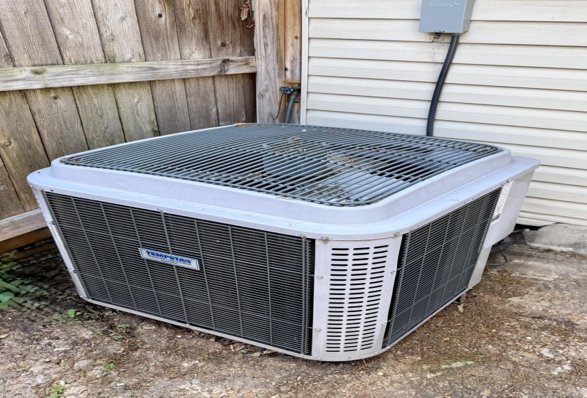 Outdoor HVAC unit with a durable metal grille and a Tempest brand plate