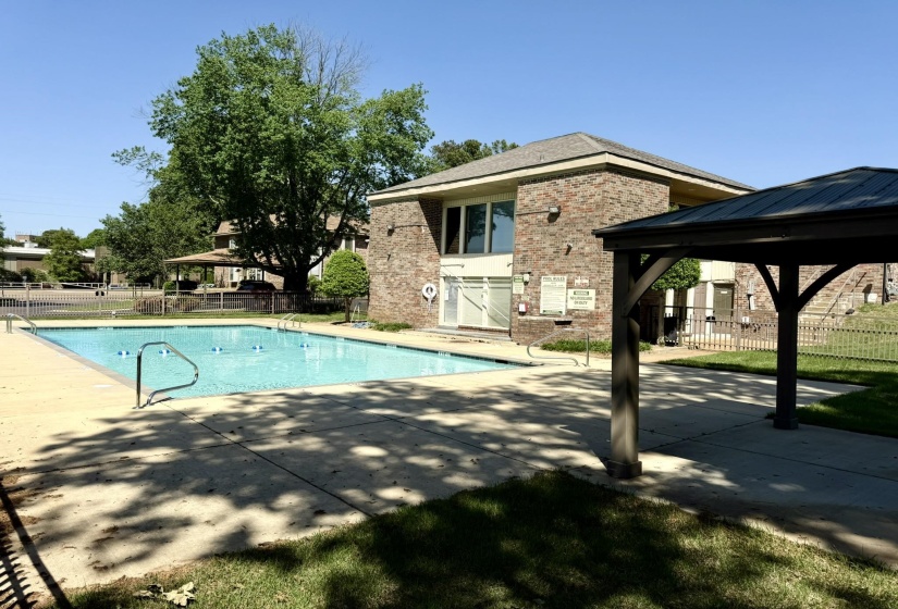 Rectangular swimming pool with integrated steps and handrails, surrounded by a concrete deck