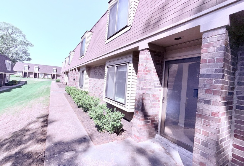 Brick exterior with a prominent glass storm door and a recessed entry