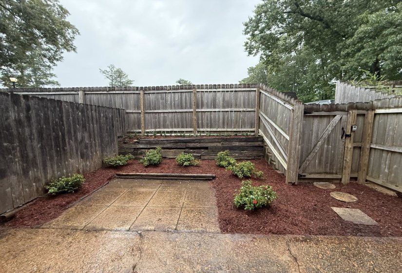 Private fenced yard featuring a concrete patio, wood fencing, and landscaped areas with shrubs