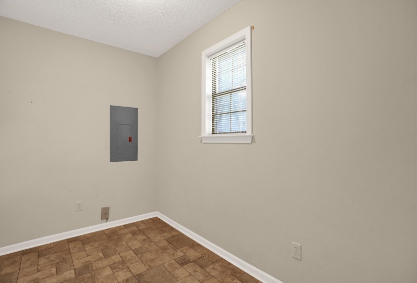 Interior room featuring textured ceilings, light-toned wall paint, and patterned tile-finish flooring