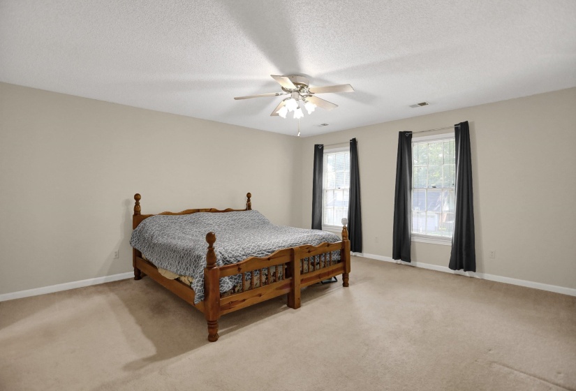 Spacious room with neutral wall tones and light-toned carpet