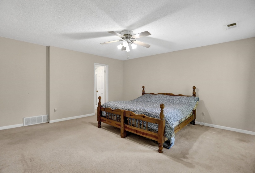 Carpeted room with neutral-toned walls, a white ceiling, and a ceiling fan with integrated lighting