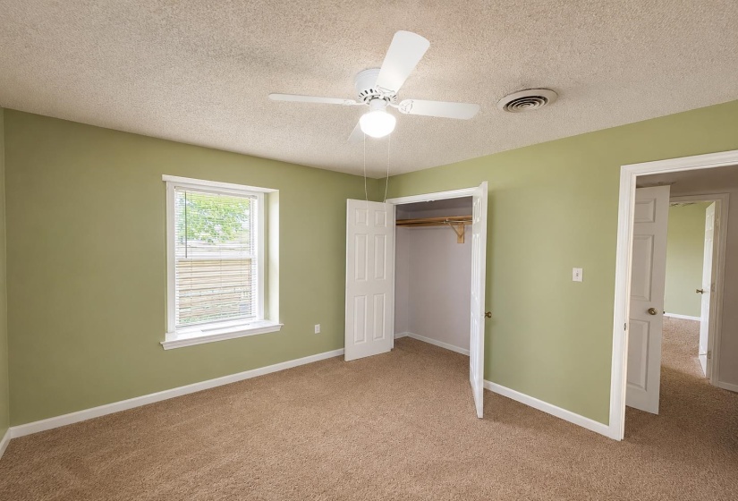 Carpeted room featuring light green walls and white trimAI-Enhanced Photo — May Not Reflect Exact Current Condition