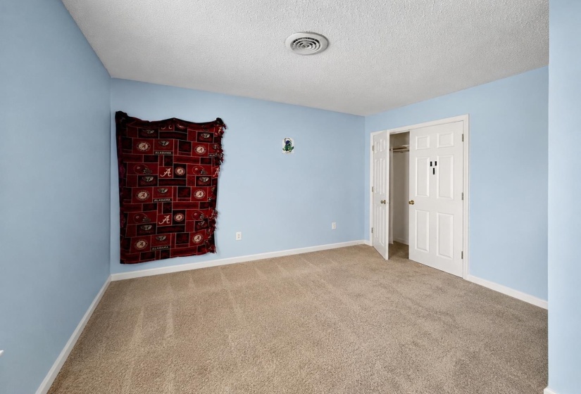 Carpeted room featuring light blue walls, a white ceiling, and white baseboards AI-Enhanced Photo — May Not Reflect Exact Current Condition
