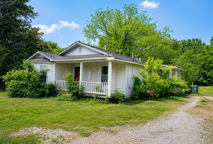 Single-story residence featuring white siding and a covered front porch with white railing AI-Enhanced Photo — May Not Reflect Exact Current Condition