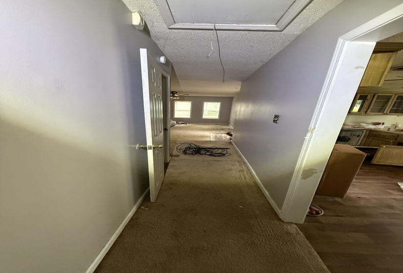 Hallway with textured ceiling and carpet flooring