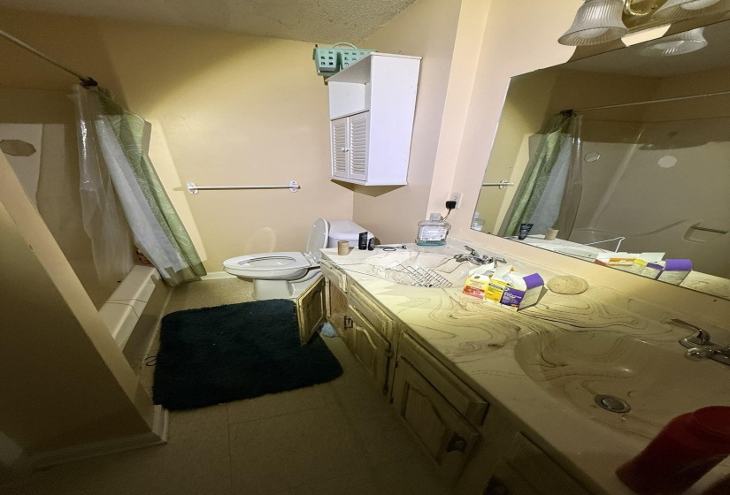 Bathroom featuring a vanity with dual integrated sinks and a patterned countertop